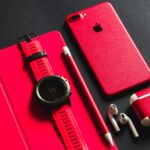 a red apple watch, headphones, and a red case